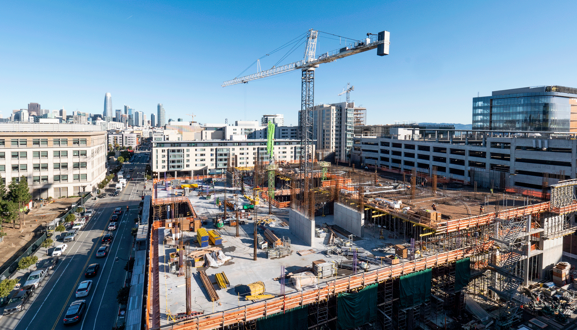 A crane stands in the middle of an active construction site.