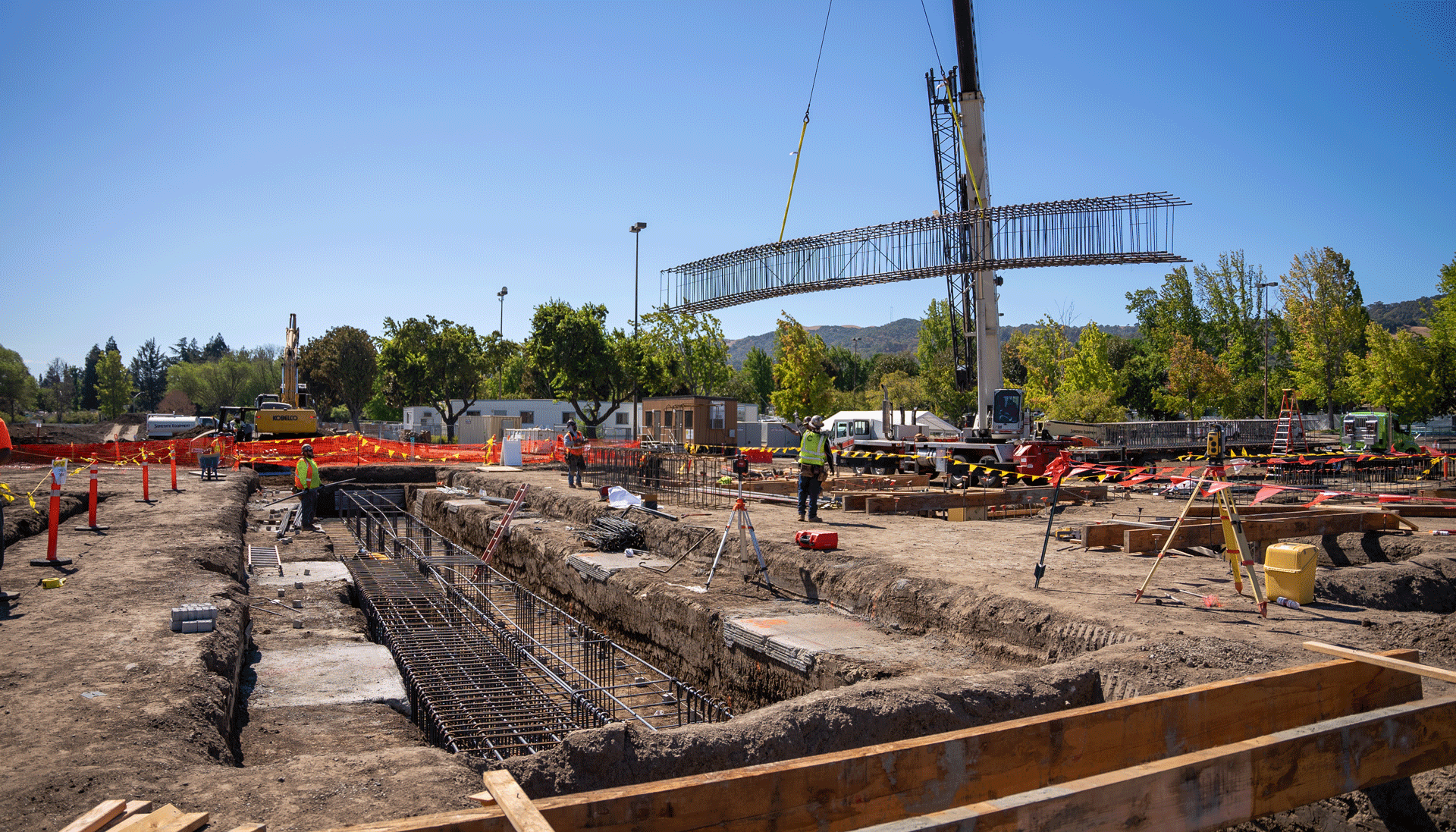 prefabricated rebar cage is lowered with a crane into a trench